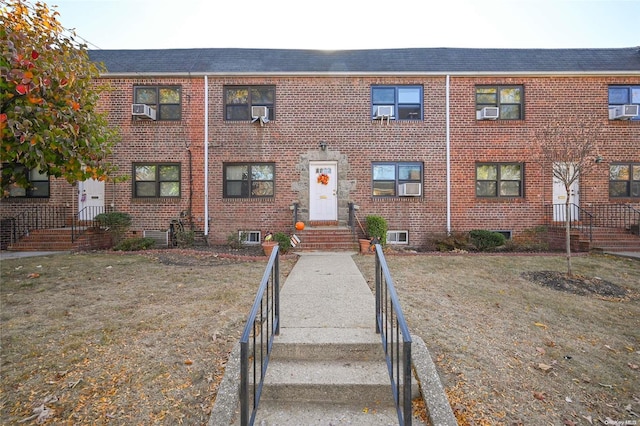 view of front of property with cooling unit and a front yard