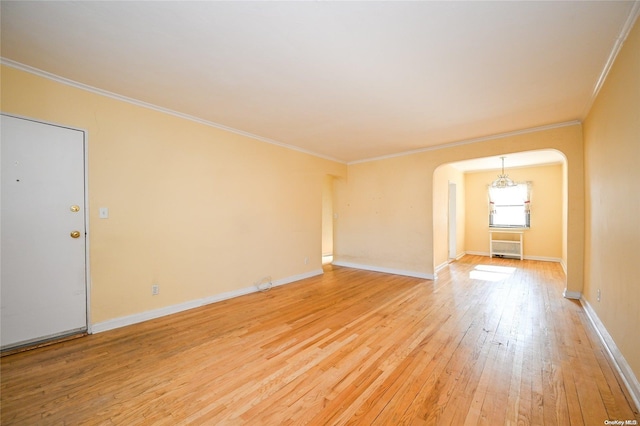 spare room featuring crown molding and light hardwood / wood-style floors