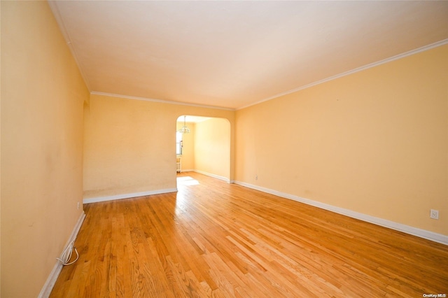 empty room with ornamental molding and hardwood / wood-style flooring