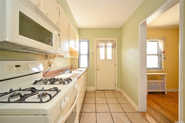 kitchen featuring white appliances, light hardwood / wood-style floors, white cabinetry, and sink