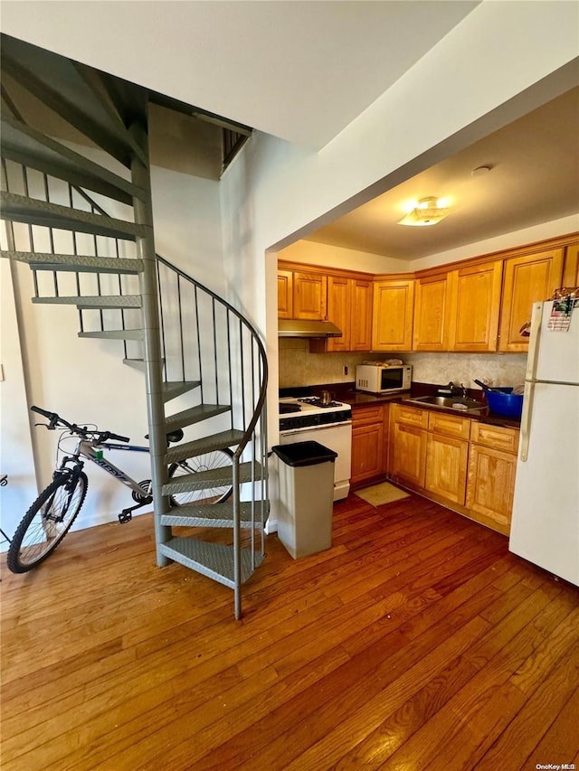 kitchen featuring sink, white appliances, dark wood-type flooring, and backsplash