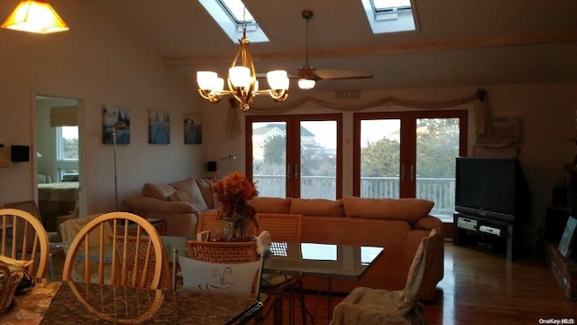 dining room featuring hardwood / wood-style flooring, ceiling fan with notable chandelier, and vaulted ceiling