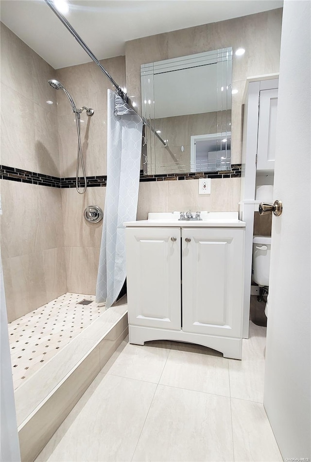 bathroom featuring a shower with curtain, vanity, tile patterned floors, and tile walls