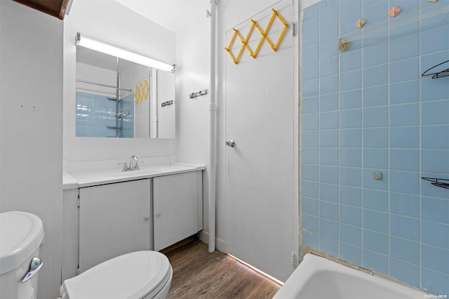 full bathroom featuring vanity, toilet, wood-type flooring, and tiled shower / bath