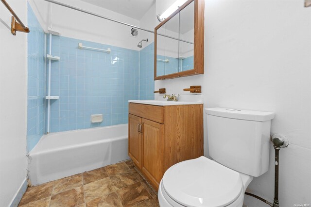 full bathroom with vanity, tiled shower / bath combo, and toilet