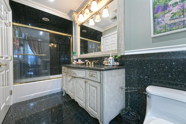 full bathroom with bath / shower combo with glass door, vanity, crown molding, tile walls, and toilet