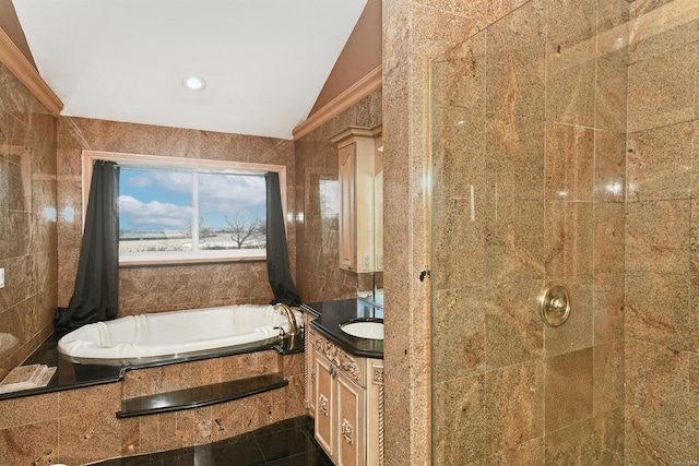 bathroom with vanity, tile walls, tiled bath, and vaulted ceiling