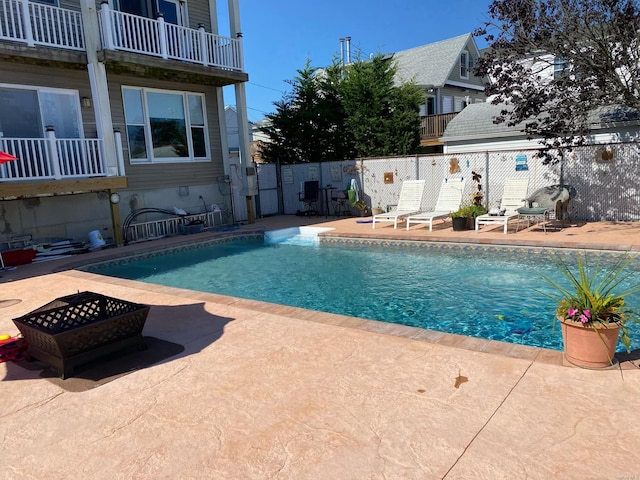 view of swimming pool featuring a patio area and a fire pit