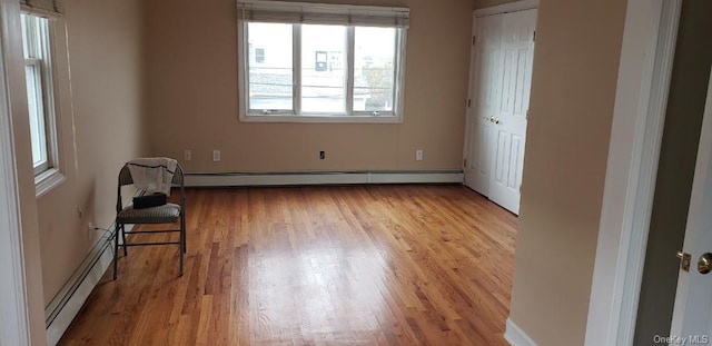 interior space with light hardwood / wood-style floors and a baseboard heating unit