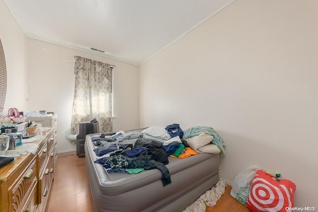 bedroom with hardwood / wood-style flooring and crown molding