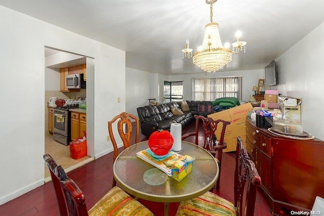 dining area with dark wood-type flooring and a notable chandelier