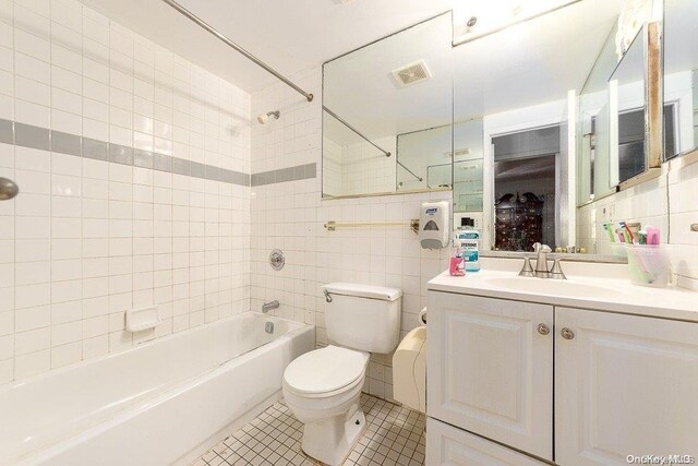 full bathroom featuring vanity, shower / tub combination, tile patterned flooring, toilet, and tile walls