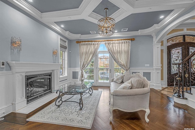 living room with a notable chandelier, crown molding, and coffered ceiling