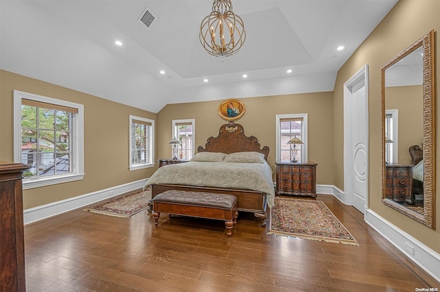 bedroom featuring vaulted ceiling, wood-type flooring, and an inviting chandelier