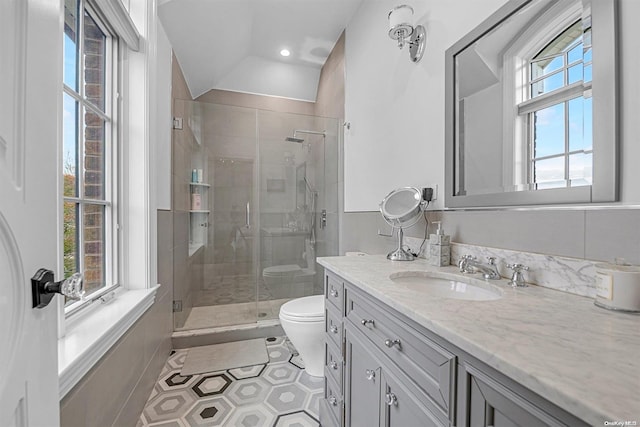 bathroom with a wealth of natural light, a shower with shower door, lofted ceiling, and toilet