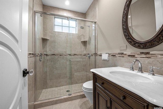 bathroom with an enclosed shower, vanity, tile walls, tile patterned flooring, and toilet