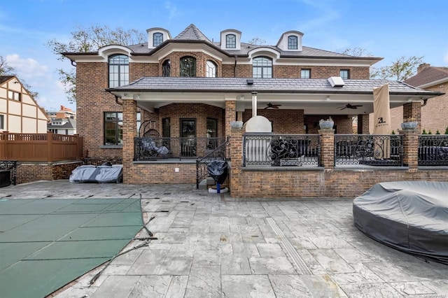 back of property featuring ceiling fan and a patio area