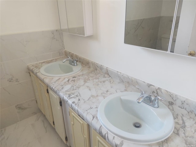 bathroom with vanity and tile walls