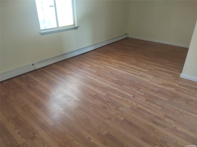 unfurnished room featuring light wood-type flooring and a baseboard radiator