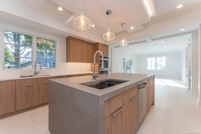 kitchen with sink, stainless steel appliances, a kitchen island with sink, and pendant lighting