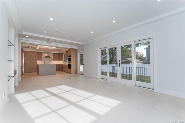 unfurnished living room with beam ceiling and french doors