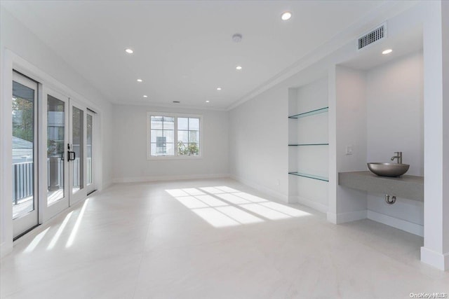 empty room featuring sink, french doors, and crown molding