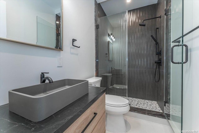 bathroom with toilet, an enclosed shower, and vanity