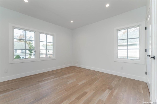 empty room with light hardwood / wood-style flooring and plenty of natural light