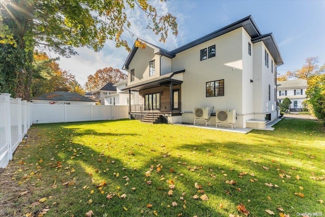 rear view of property with ac unit, a patio area, and a lawn