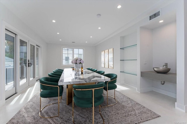 dining room with sink, french doors, crown molding, and built in features