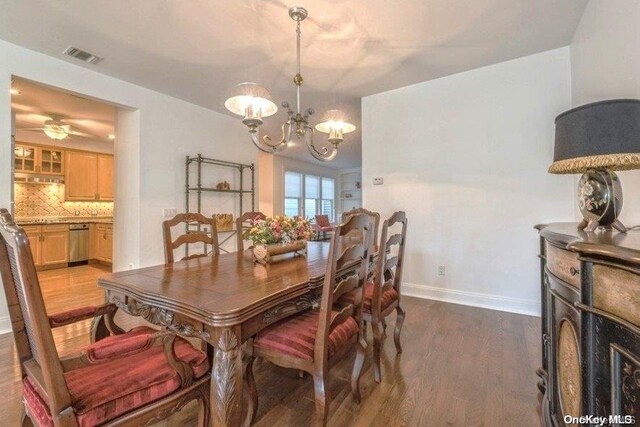 dining space featuring dark hardwood / wood-style floors and ceiling fan with notable chandelier