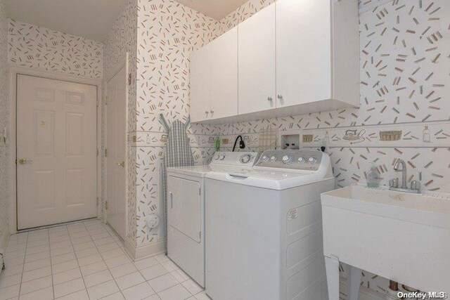 washroom featuring cabinets, independent washer and dryer, light tile patterned flooring, and sink