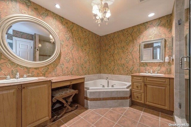 bathroom with tile patterned flooring, shower with separate bathtub, vanity, and a notable chandelier