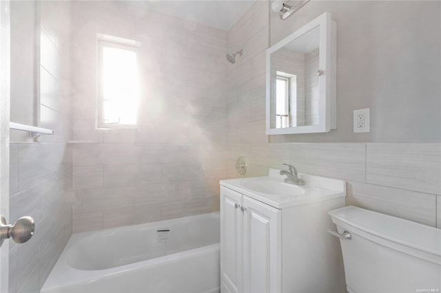 full bathroom featuring vanity, tiled shower / bath, tile walls, and toilet