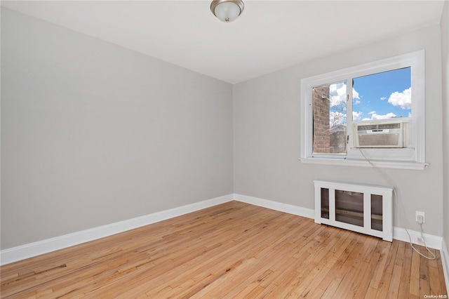 empty room with light wood-type flooring and cooling unit