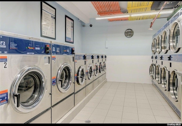 clothes washing area featuring washing machine and clothes dryer and tile patterned floors