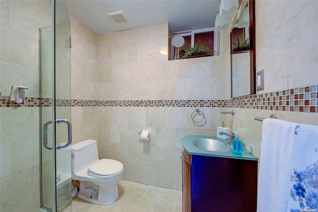 bathroom with vanity, tile patterned floors, toilet, tile walls, and walk in shower