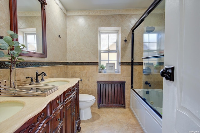 full bathroom with vanity, combined bath / shower with glass door, tile patterned flooring, toilet, and tile walls