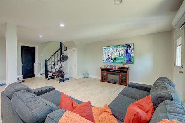 living room with light wood-type flooring and a wall unit AC