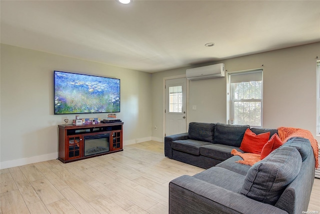 living room featuring a wall mounted air conditioner and light hardwood / wood-style floors