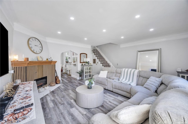 living room with ornamental molding and light hardwood / wood-style floors