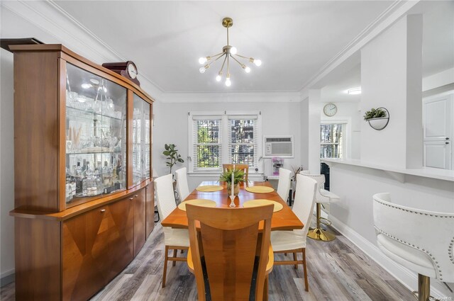 dining space with crown molding, wood-type flooring, an AC wall unit, and a chandelier