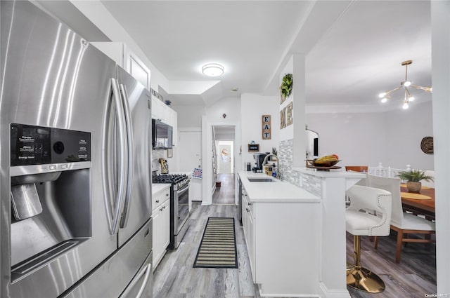 kitchen with sink, backsplash, white cabinets, and appliances with stainless steel finishes