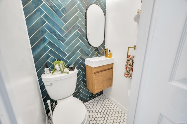 bathroom featuring vanity, toilet, tile patterned flooring, and tile walls