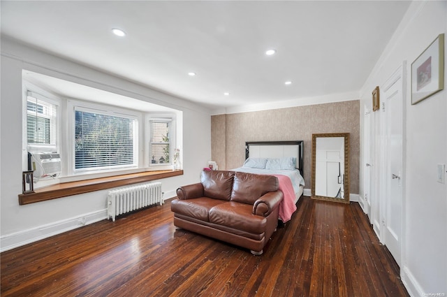 bedroom featuring dark hardwood / wood-style flooring, radiator, multiple windows, and cooling unit