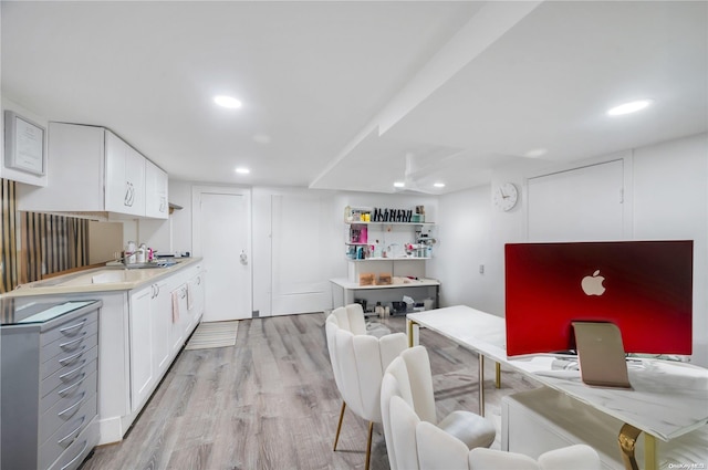 kitchen with sink, white cabinets, and light hardwood / wood-style flooring