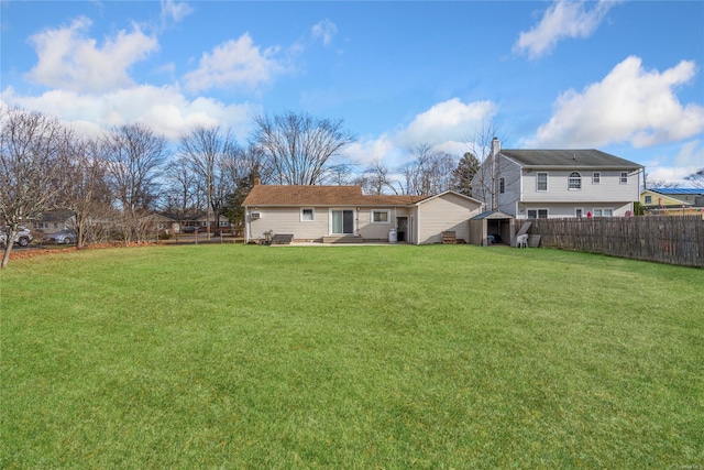 back of property with a lawn and a storage shed