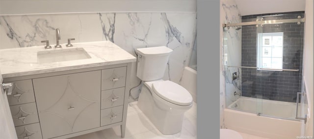 full bathroom with vanity, bath / shower combo with glass door, and toilet