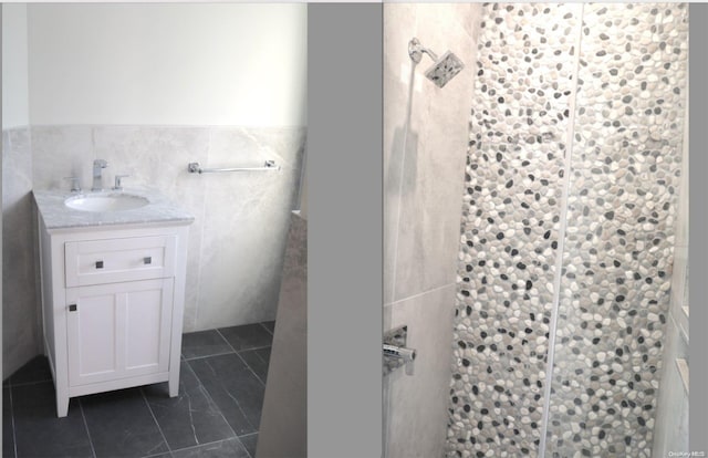 bathroom featuring tile patterned flooring, vanity, tile walls, and walk in shower