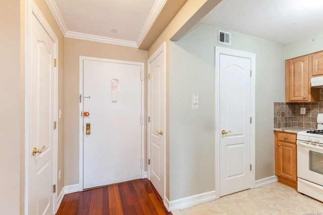 interior space with decorative backsplash, light brown cabinetry, ornamental molding, white range, and light hardwood / wood-style floors